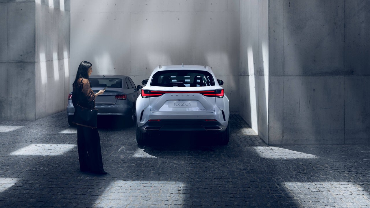 A woman standing by the Lexus NX 