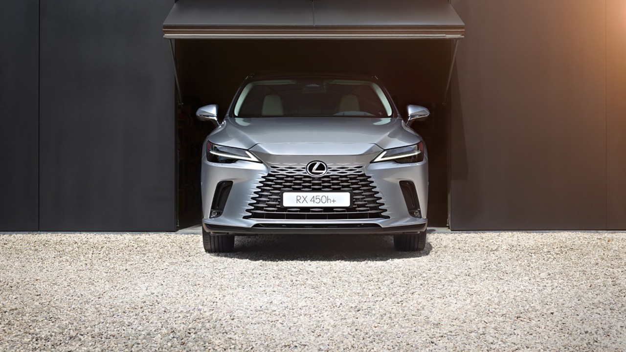 A Lexus RX 450h+ parked in a garage opening