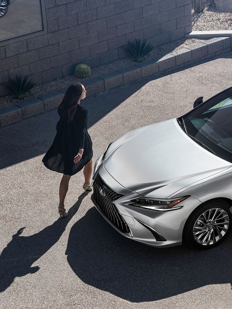 A woman walking towards a Lexus ES 300h 