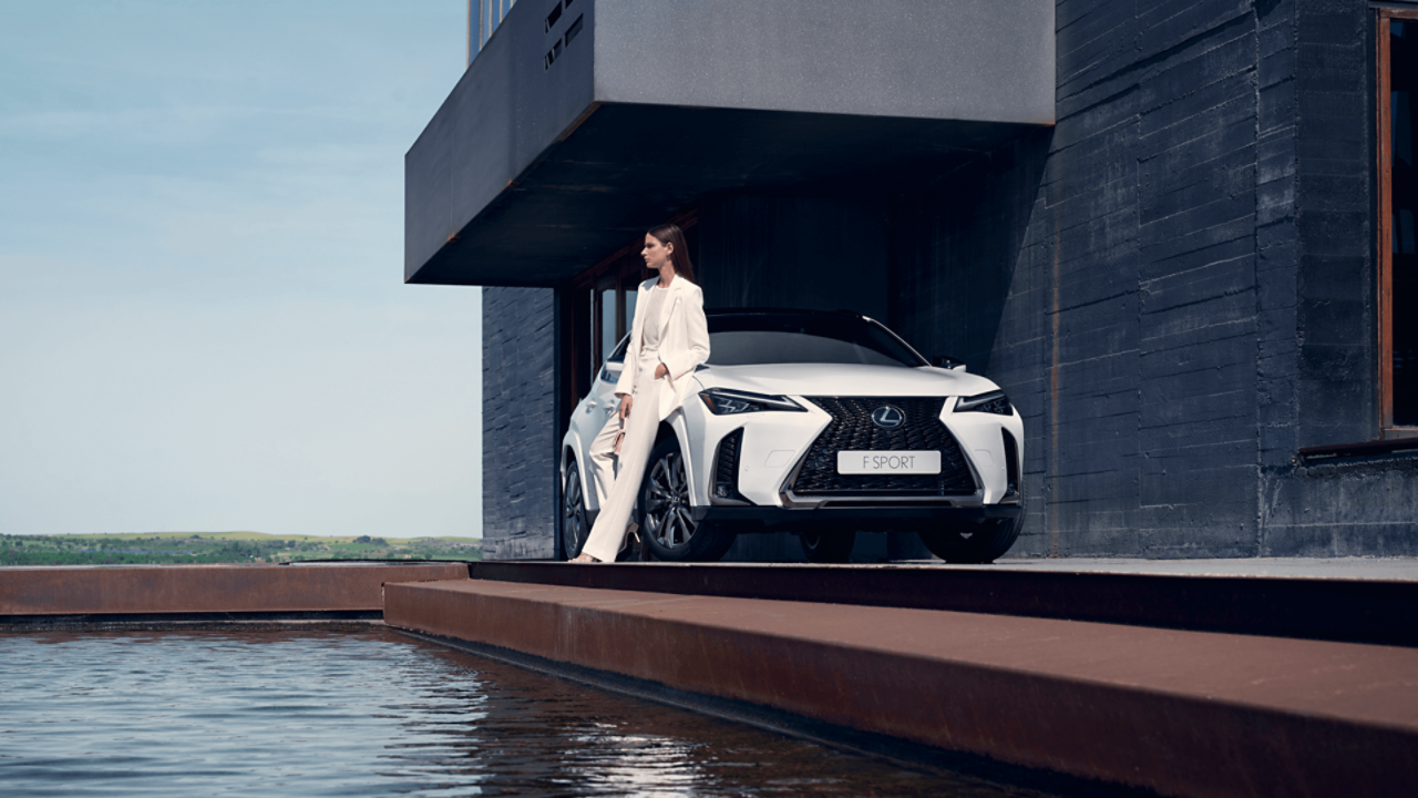  A women leaning against a parked Lexus UX