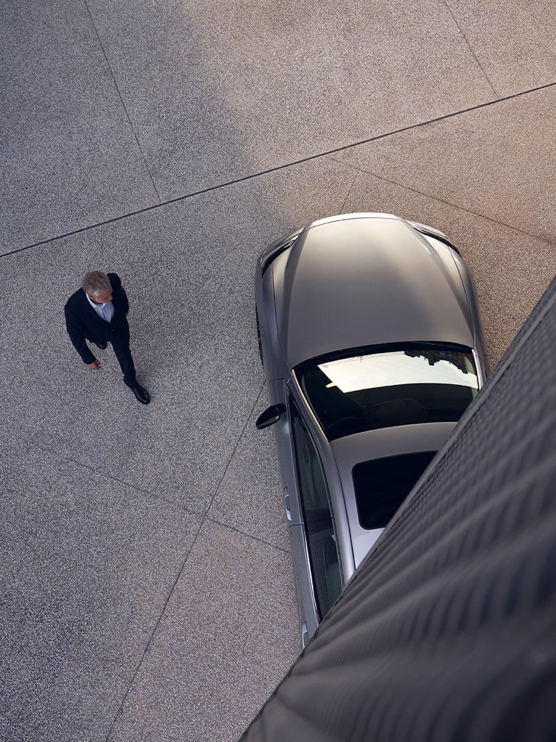 A man walking towards a parked Lexus 