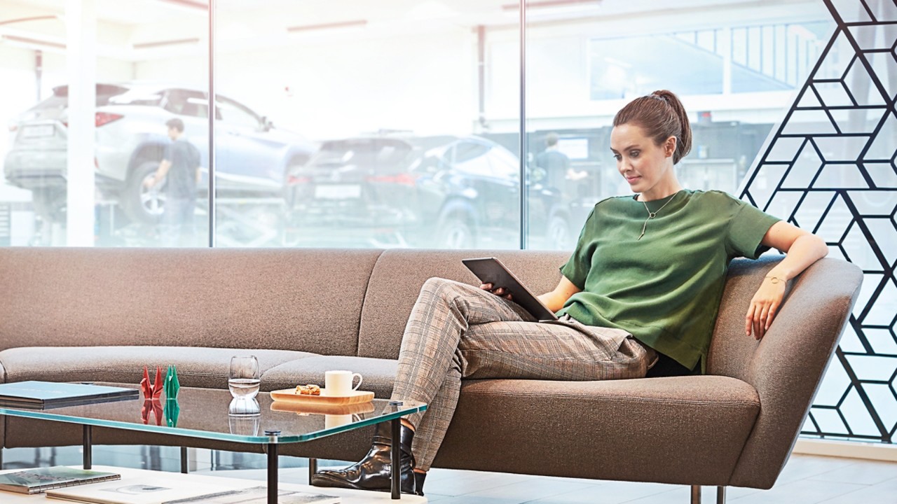A woman using a tablet at a Lexus dealership