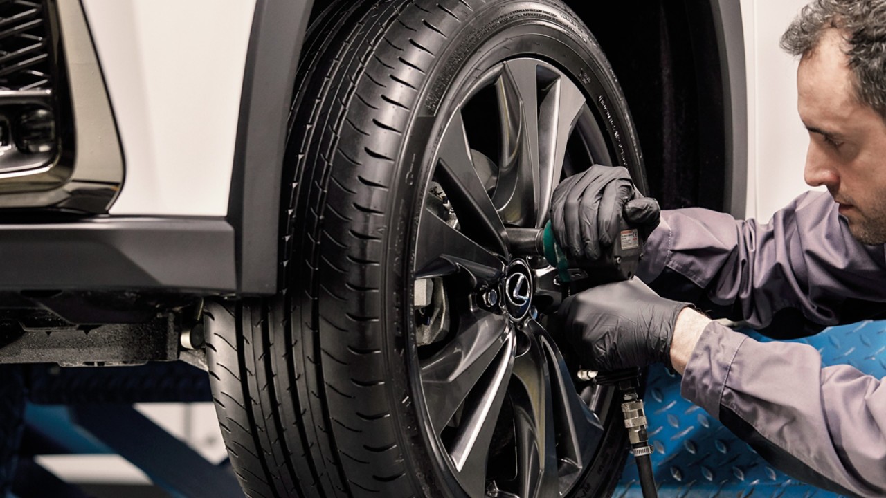 A mechanic working on a Lexus wheel