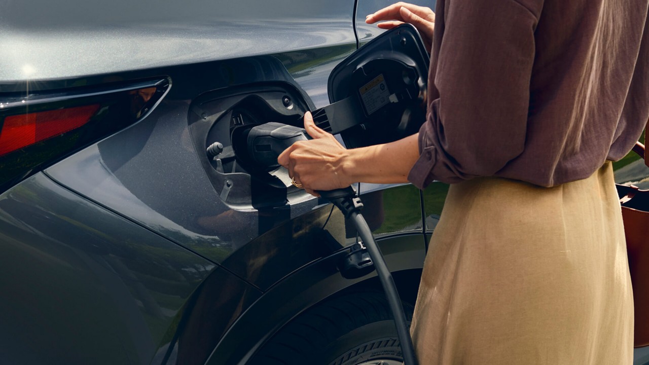 A woman plugging in a Lexus